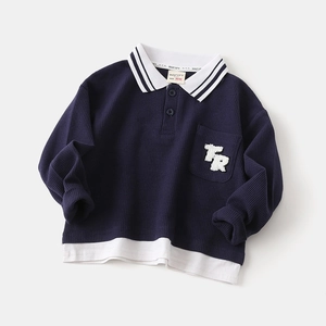 Detail of waffle texture fabric and striped collar on a navy blue long-sleeved polo shirt
