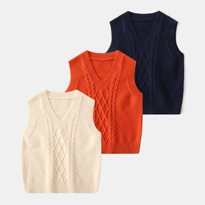 Detail of V-neck knitted vests featuring cable knit patterns in navy, orange and cream