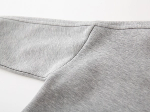 Gros plan des coutures de qualité sur le sweat enfant en maille chinée grise ultra douce