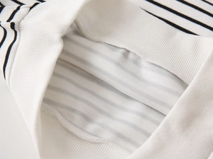 Detailed macro view of striped cotton ribbed hem and high-quality stitching on children sweater