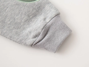 Close-up of grey knitted sweatshirt cuff with detailed ribbed elastic texture and finish
