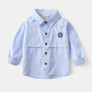 Close-up of boys' blue striped shirt featuring detailed navy letter embroidery on chest
