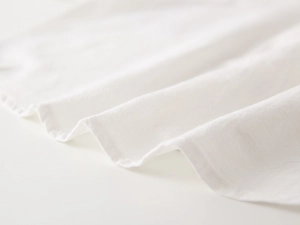 Macro detail of high-quality white cotton linen fabric showing fine texture and softness