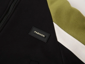 Close-up of color-block jacket fabric with zipper detail and fashion rubber patch