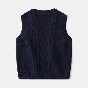 Detailed close-up of dark blue knit vest featuring V-neck and classic cable knit textures