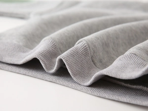 Macro shot of grey heather knitted rib cuffs and texture on boys' casual sweatshirt