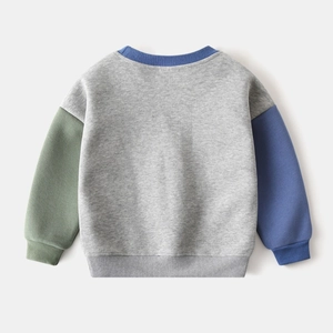 Detailed close-up of colorful patchwork sleeves on children's loose cotton sweatshirt