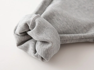 Vue macro du poignet en coton gris avec coutures de renfort sur le bord de la manche