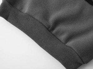 Détail d'un sweat en polaire gris foncé montrant les poignets côtelés et la maille de coton