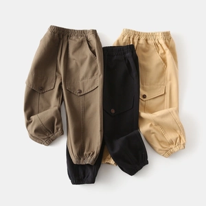Macro shot of cargo pants showing elastic waistband and large button flap pockets
