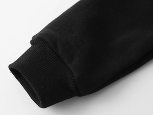 Gros plan des poignets côtelés du sweat noir pour enfant avec maille premium