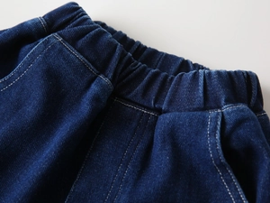 Macro view of elastic waistband on dark blue denim jeans with white stitching details