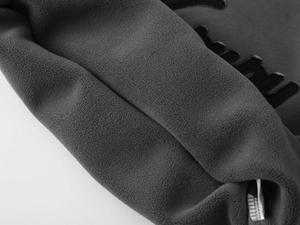 Détail macro du tissu polaire gris anthracite avec broderie en relief et texture