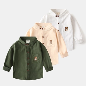 Détail de chemises pour enfants en coton avec col en V et broderie d'ours sur la poche