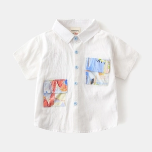 Detail of white cotton boy's shirt showing colorful artistic pockets and blue buttons