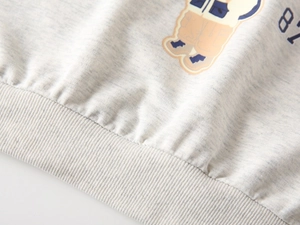 Detail of ribbed hem and cartoon bear print on light gray cotton blend kids sweatshirt
