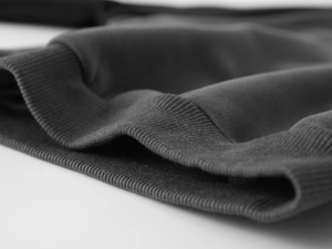 Détail du poignet en tricot côtelé sur un pull épais pour enfant en polaire gris foncé