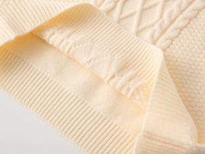 Detail view of boys knitted V-neck vest showing intricate cable and honeycomb stitch patterns