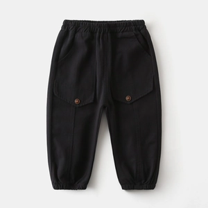 Detail view of boys black cargo pants featuring elastic waist and large flap pockets
