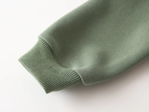 Close-up of the elastic ribbed cuffs on a moss green cotton sweatshirt for boys