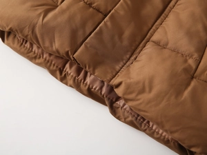 Macro shot of dark brown quilted fabric with satin finish and even stitching detail