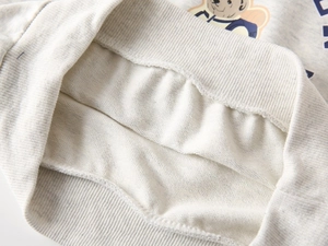 Detail of light gray sweatshirt fabric with bear print and ribbed elastic hem