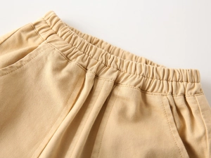 Close-up of elastic waistband and stitching on boys' beige cotton casual pants