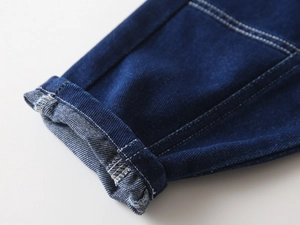 Detail of boys dark blue denim cuff showing twill weave and white contrast stitching