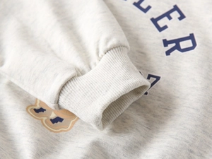 Detail of ribbed cuffs and bear print on gray vintage-style sweatshirt for boys