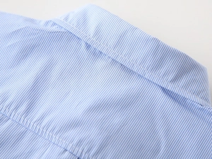 Detail of blue and white striped fabric with precise double-needle stitching on back shoulder