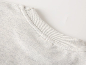 Detail of grey knitted sweatshirt neckline featuring reinforced double-needle stitching