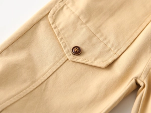 Close-up of khaki twill cotton trousers showing pocket detail with a resin button