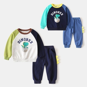 Détail de deux ensembles de survêtements dinosaures en coton pour garçons avec décorations