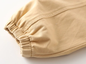 Detail of khaki boys' cotton pants showing elastic cuffs and premium twill fabric texture