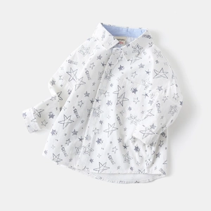 Detail showing blue star print and brand label on a white cotton boy long sleeve shirt