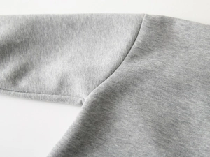 Gros plan des coutures d'épaule d'un sweat-shirt à capuche gris de qualité pour enfants