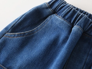 Detail of boys blue cotton denim jeans showing elastic waistband and stitching