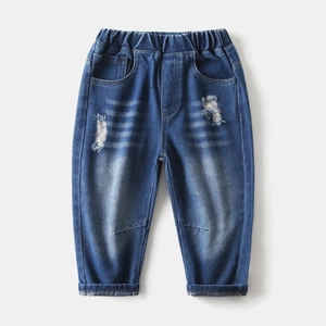 Detail of boys distressed denim jeans showing elastic waistband and ripped textures