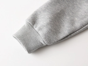 Vue détaillée du poignet en tricot côtelé gris d'un sweat à capuche pour enfant