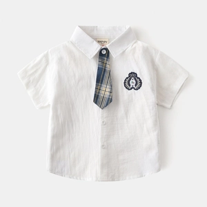 Détail d'une chemise blanche à manches courtes avec écusson brodé et cravate à carreaux