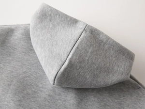 Gros plan détaillé de la couture et de la texture du sweat-shirt à capuche gris chiné