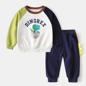 Détail d'un survêtement dinosaure pour enfant avec manches raglan et aileron jaune décoré