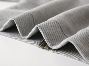 Vue détaillée du bord-côte et de la texture en maille du sweat à capuche gris enfant