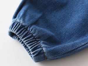 Detailed macro view of elastic cuffs on blue denim jeans with orange contrast stitching