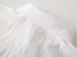 Close-up of boys white cotton shirt collar showing natural texture and neat stitching