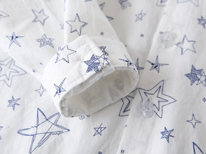Detail of boys' white shirt showing cotton twill fabric and blue star print with buttons