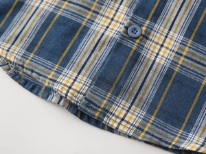 Gros plan détaillé du tissu à carreaux bleu et jaune avec bouton en résine de qualité