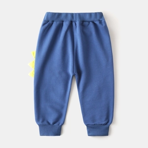 Vue détaillée du pantalon bleu enfant avec ailerons de dinosaure 3D jaunes et bords-côtes