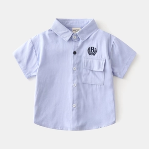 Detail of light blue cotton shirt for boys featuring chest pocket and letter B embroidery