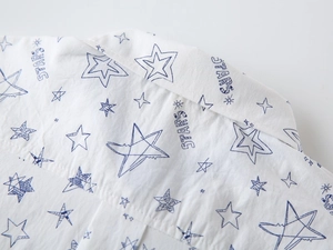 Detail shot of white cotton shirt featuring navy blue star prints and STARS lettering